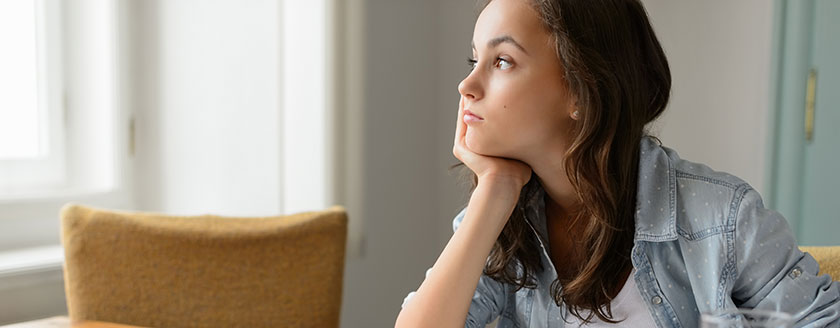 Girl At Desk Looking Out Window