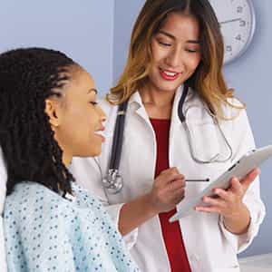 Asian Female Doctor With  Black Female Patient